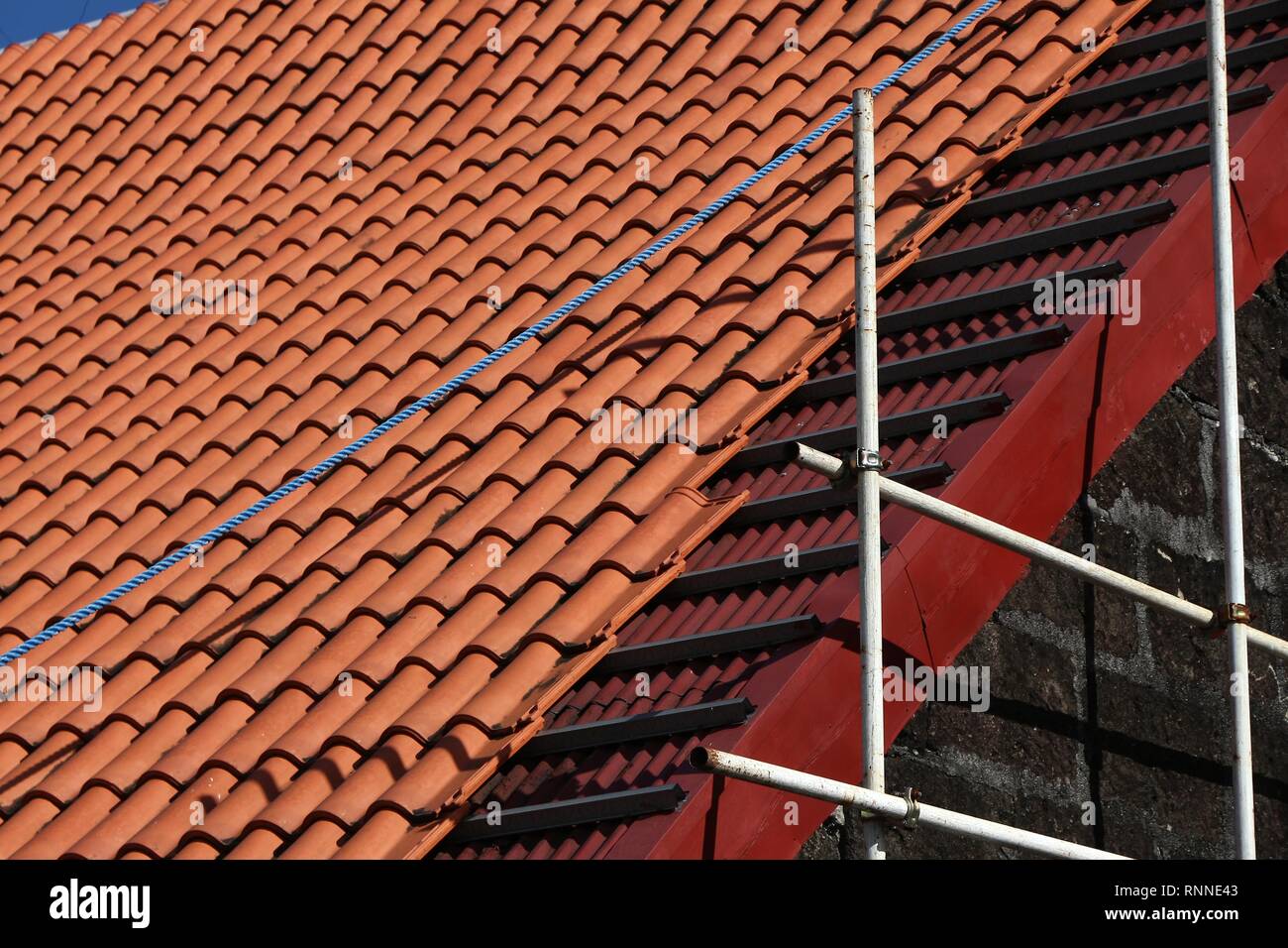 Roofing works in progress - ceramic tiles installed on old building in Philippines. Stock Photo