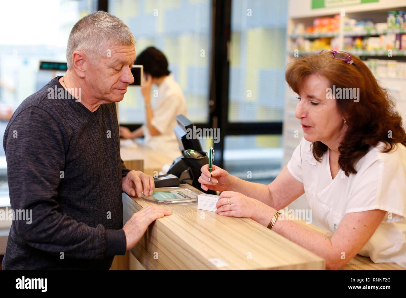 Customer advised by pharmacist in pharmacy, Czech Republic Stock Photo