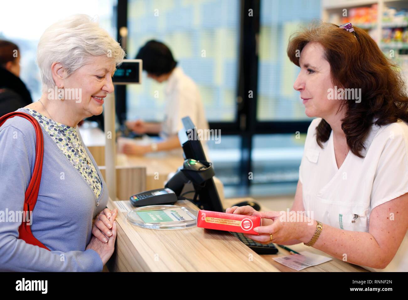 Customer is advised by pharmacist about medication in pharmacy, Czech Republic Stock Photo