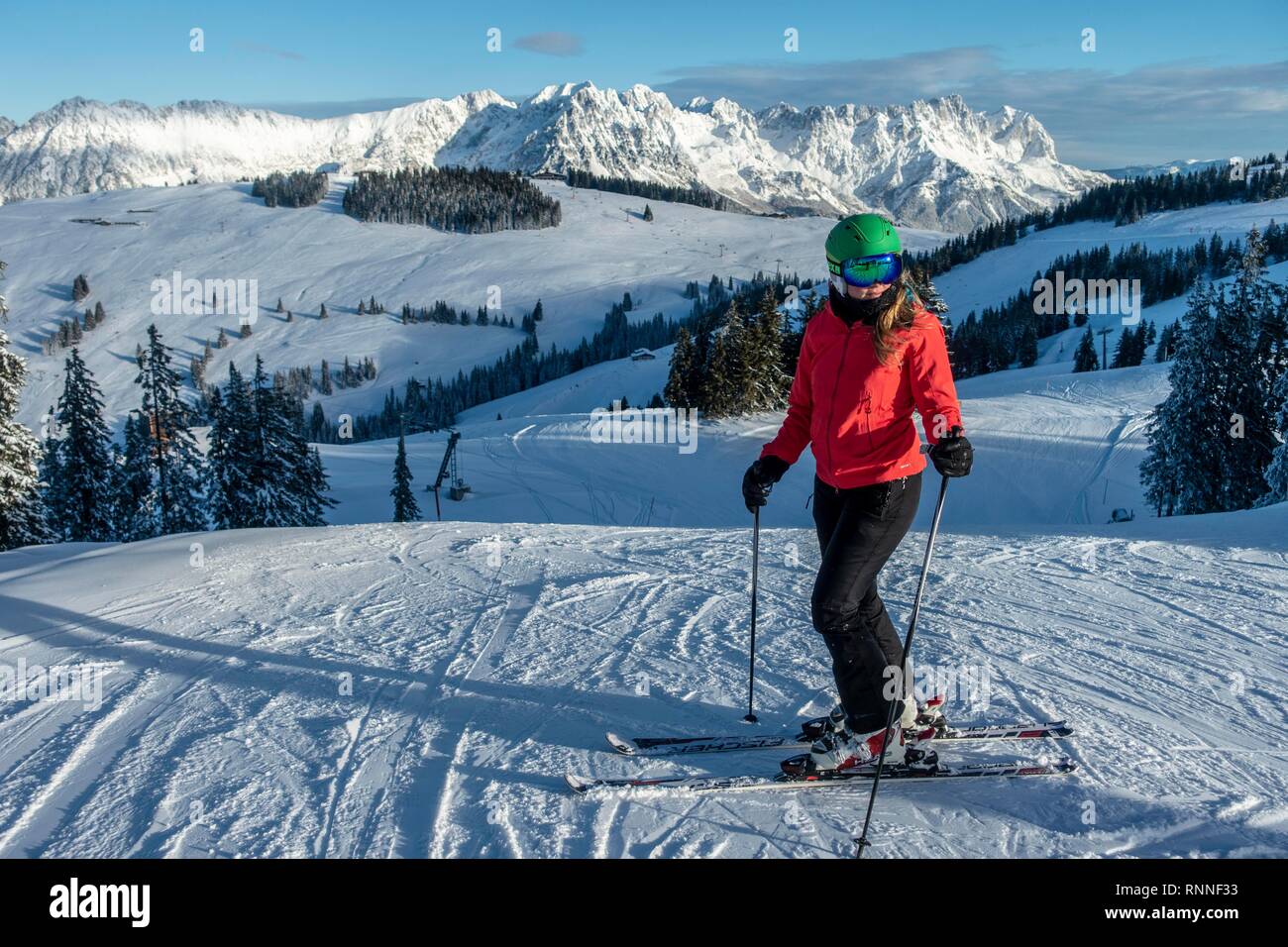 Woman skiing, view from the ski area SkiWelt Wilder Kaiser Brixenthal to the mountain massif Wilder Kaiser, Tyrol, Austria Stock Photo