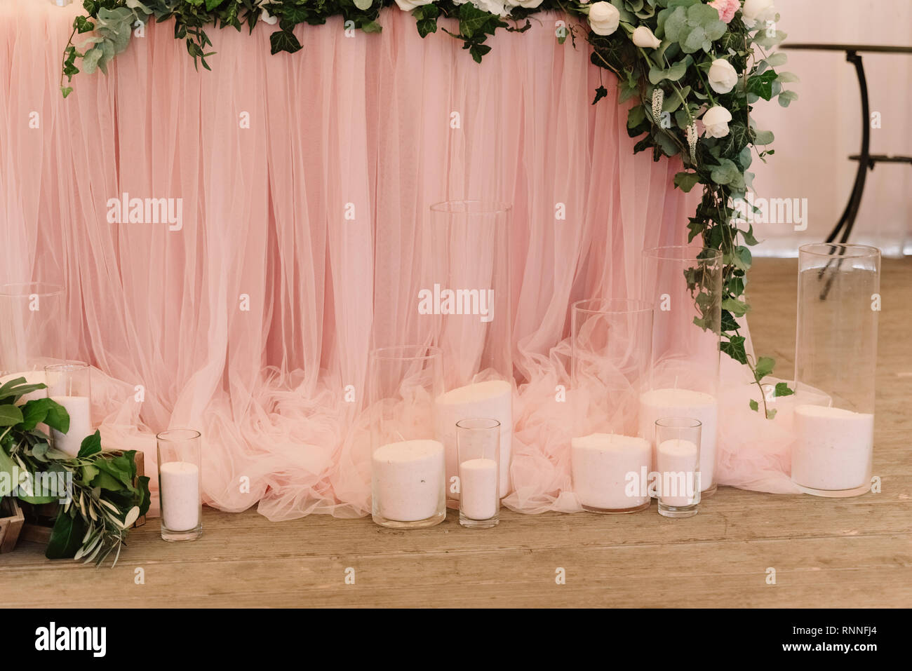 It is a lot of white candles on a floor near a table. Wedding candles