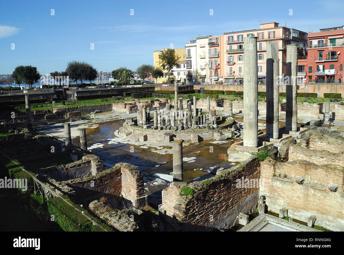 Pozzuoli, Campania, Italy. The Macellum : it  was the macellum or market building of the Roman colony of Puteoli, now the city of Pozzuoli in southern Italy. When first excavated in the 18th century, the discovery of a statue of Serapis led to the building being misidentified as the city's serapeum or Temple of Serapis. The Macellum is periodically submerged in part by the sea due to the bradyseism of volcanic origin that affects the Phlegraean Fields. The level reached by the water is visible on the columns. The holes left by the Lithophaga molluscs are also visible on the columns. Stock Photo