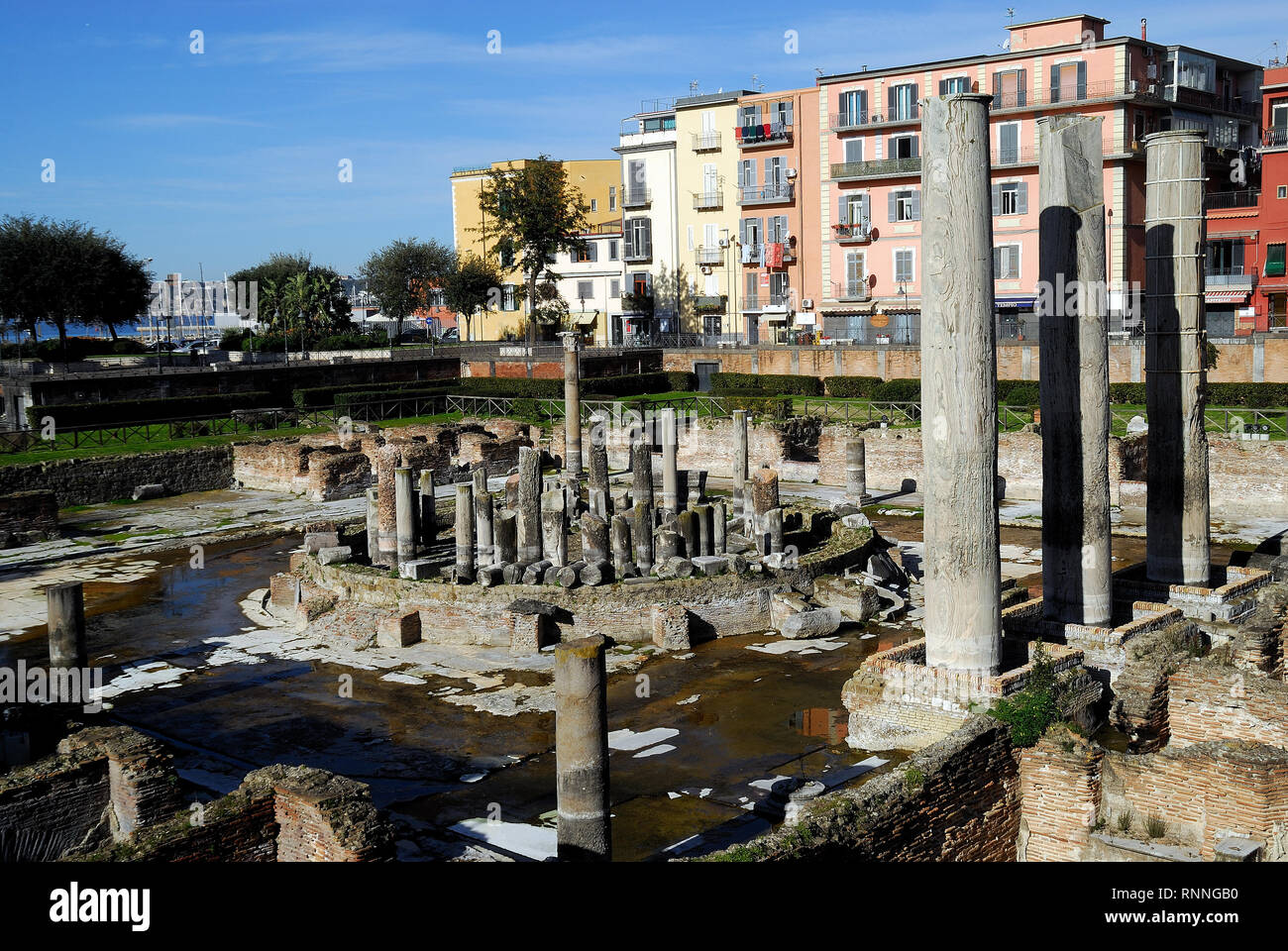 Pozzuoli, Campania, Italy. The Macellum : it  was the macellum or market building of the Roman colony of Puteoli, now the city of Pozzuoli in southern Italy. When first excavated in the 18th century, the discovery of a statue of Serapis led to the building being misidentified as the city's serapeum or Temple of Serapis. The Macellum is periodically submerged in part by the sea due to the bradyseism of volcanic origin that affects the Phlegraean Fields. The level reached by the water is visible on the columns. The holes left by the Lithophaga molluscs are also visible on the columns. Stock Photo