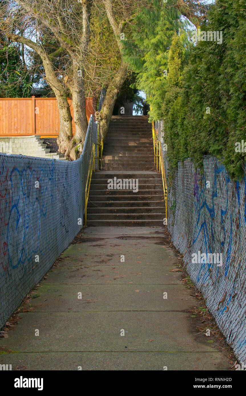 A concrete stairway along a pathway in between houses in a neighbourhood of Maple Ridge, British Columbia. Stock Photo