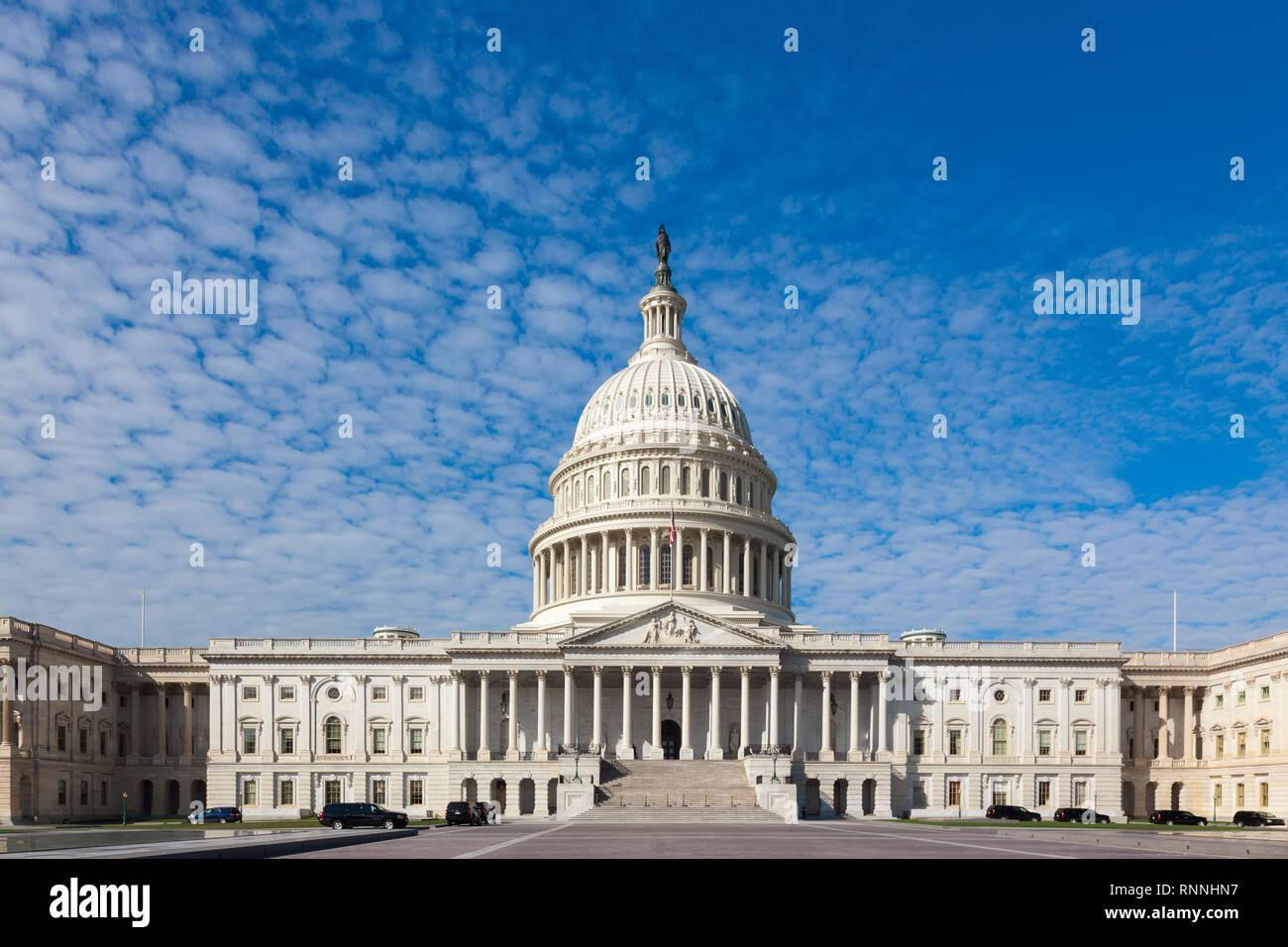 Capitol USA Building at day. People tourists on background of east front at day. White feather clouds and blue sky. United States Congress. Washington Stock Photo