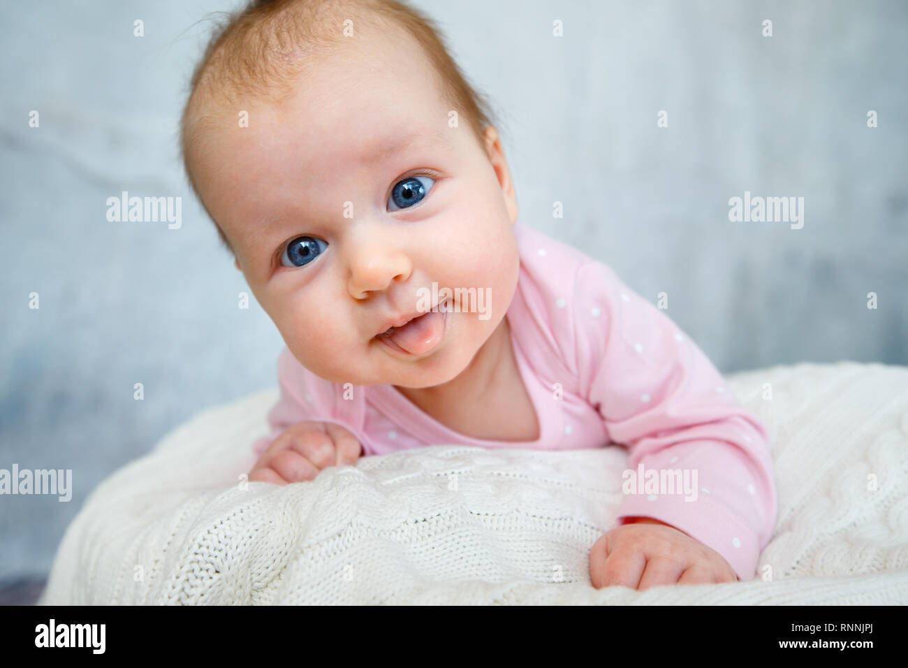 Portrait of a cute newborn baby lying on her stomach Stock Photo