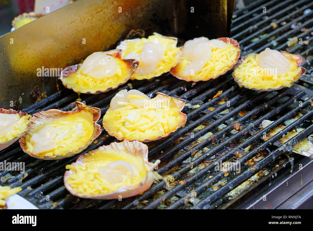 Broiled scallops with cheese on the shell at a fish market in Sydney