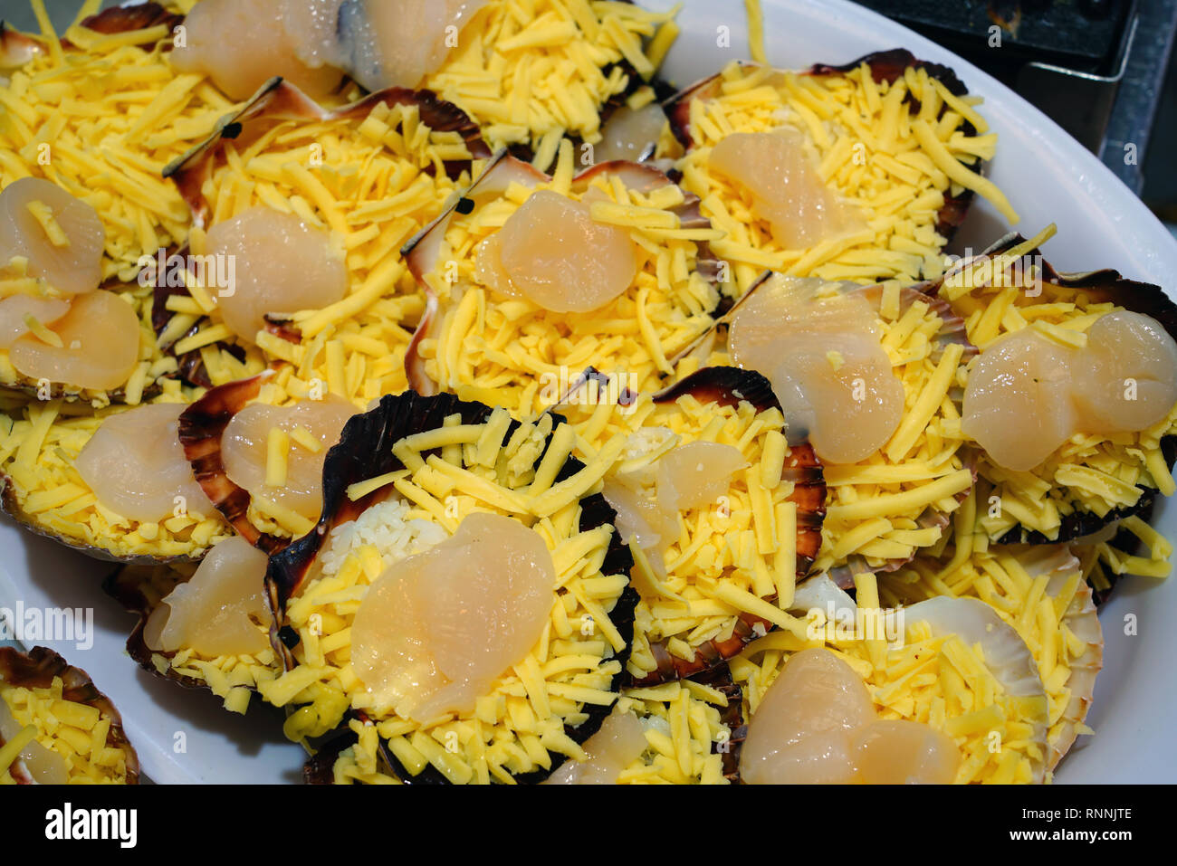 Broiled scallops with cheese on the shell at a fish market in Sydney