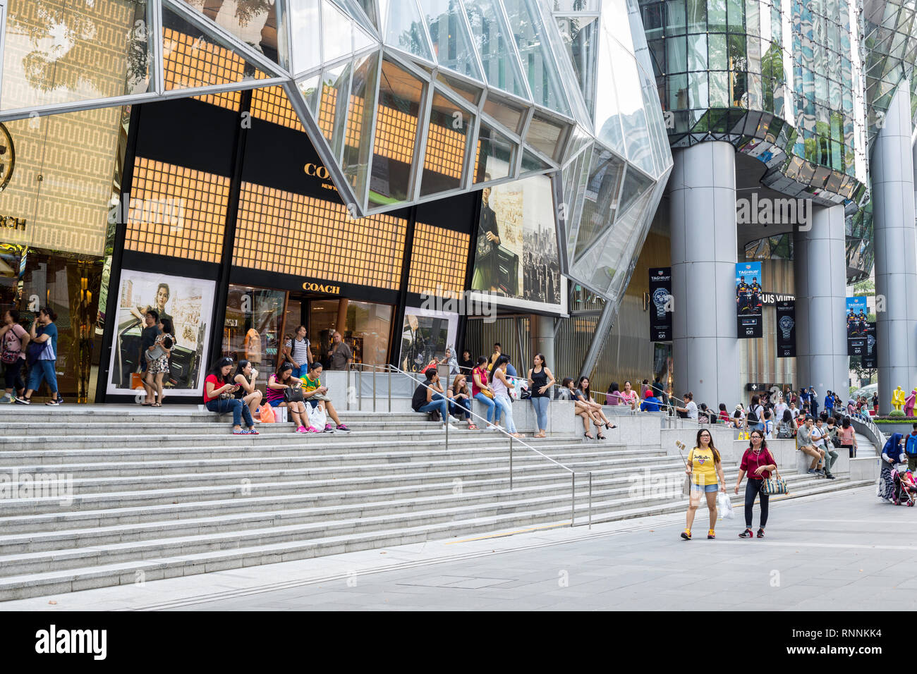 Singapore, Orchard Road Street Scene, Shoppers Taking a Break outside the ION Mall. Stock Photo