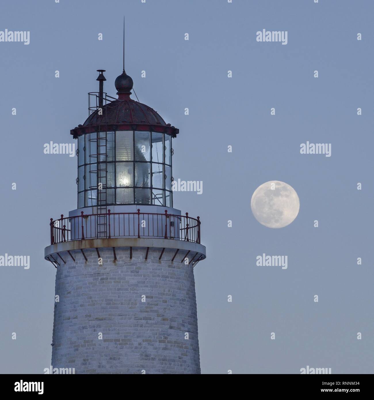 Lighthouse with February super moon in the background. Stock Photo