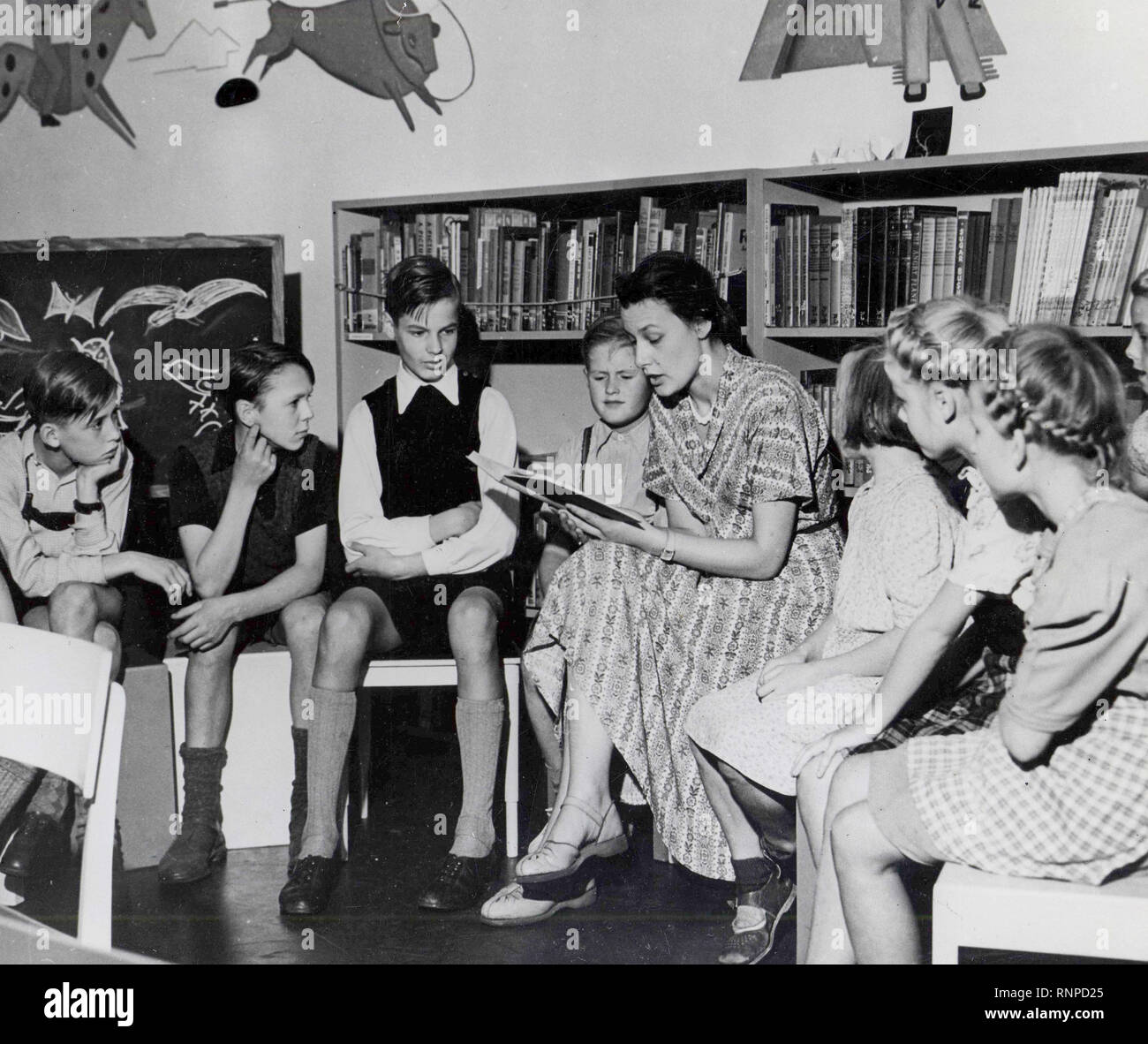 Employee Reads Stories To A Group Of Youngsters In The Children S