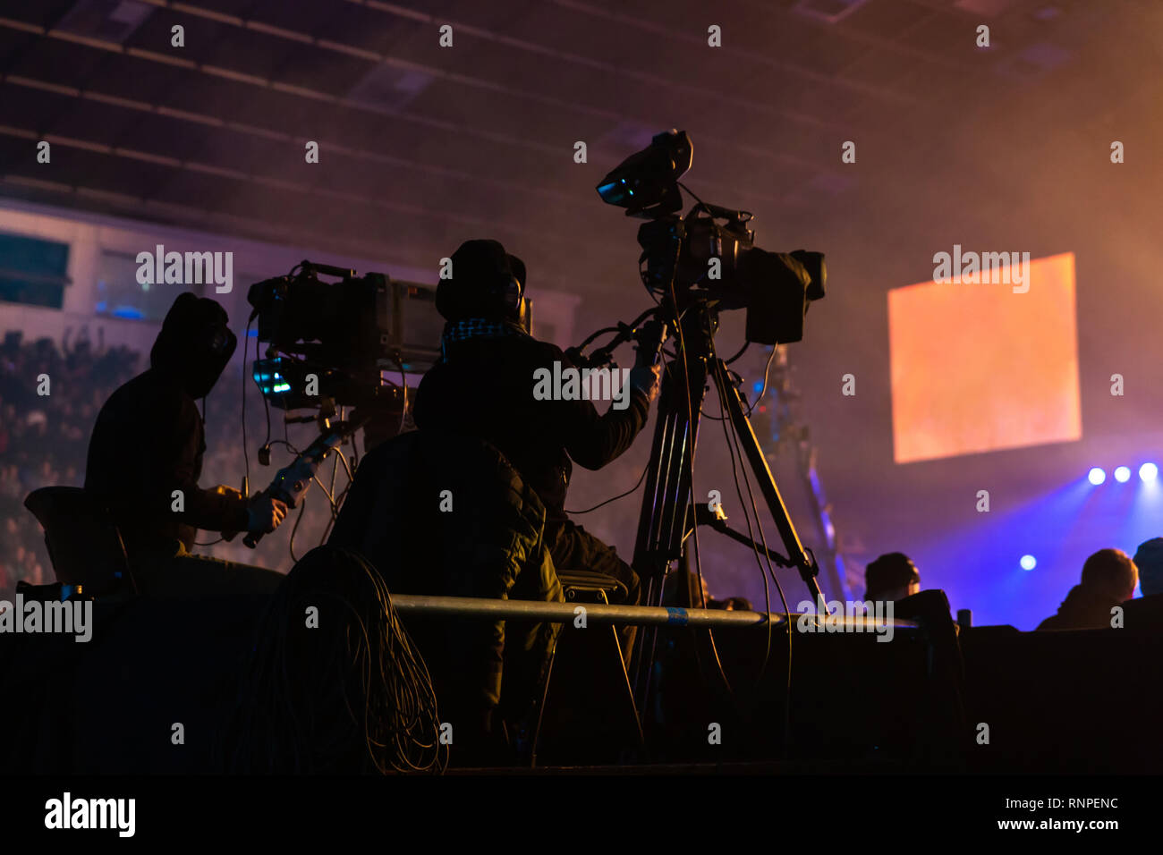 Silhouette of a group of cameramen broadcasting an event. Workers are