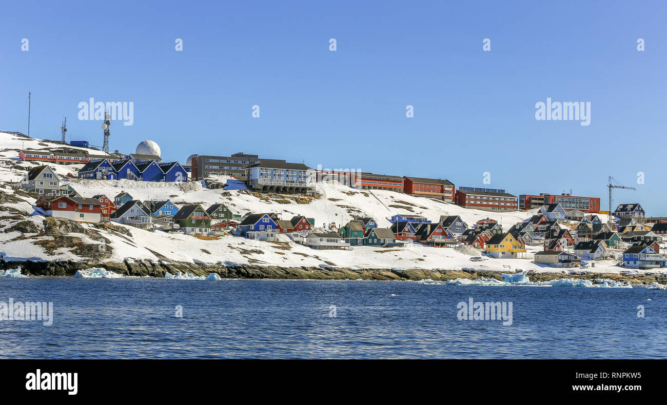 Lots of Inuit huts and living buildings scattered on the rocky coast along the fjord, Nuuk city, Greenland Stock Photo