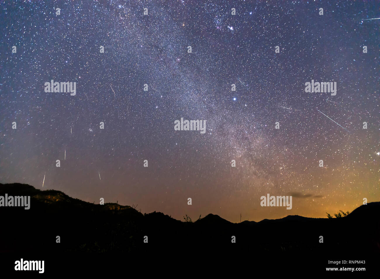 Geminid Meteor Shower and the Milky Way Over a mountain. Geminid Meteor in the night sky Stock Photo