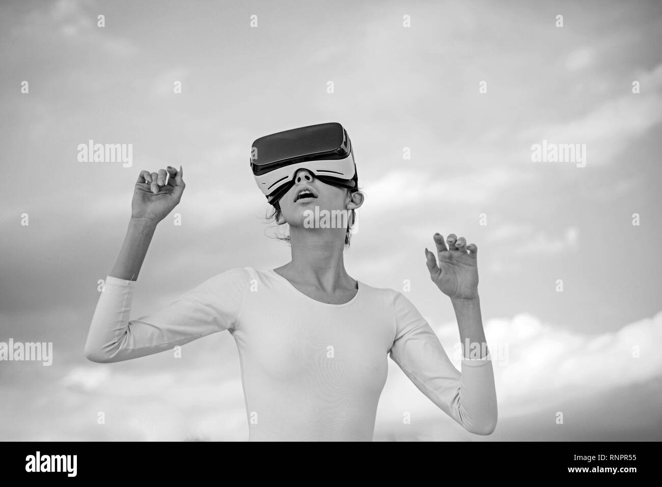 Future is now. Young woman gesturing in vr glasses. Pretty girl wear virtual reality headset. Cute girl play in simulated environment. Innovative vr Stock Photo