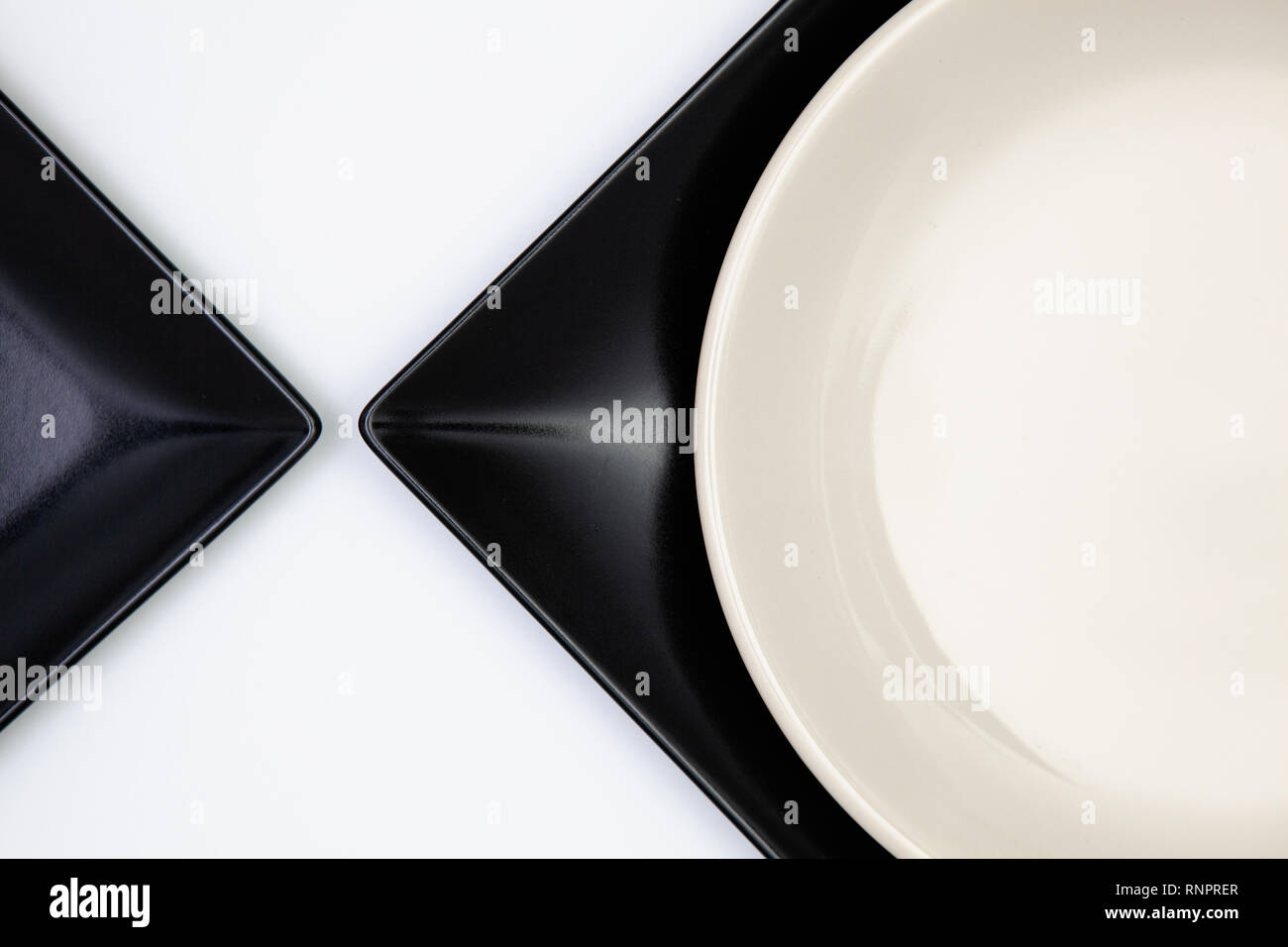 Different black and white plates on the white table.Top view. Flat Lay