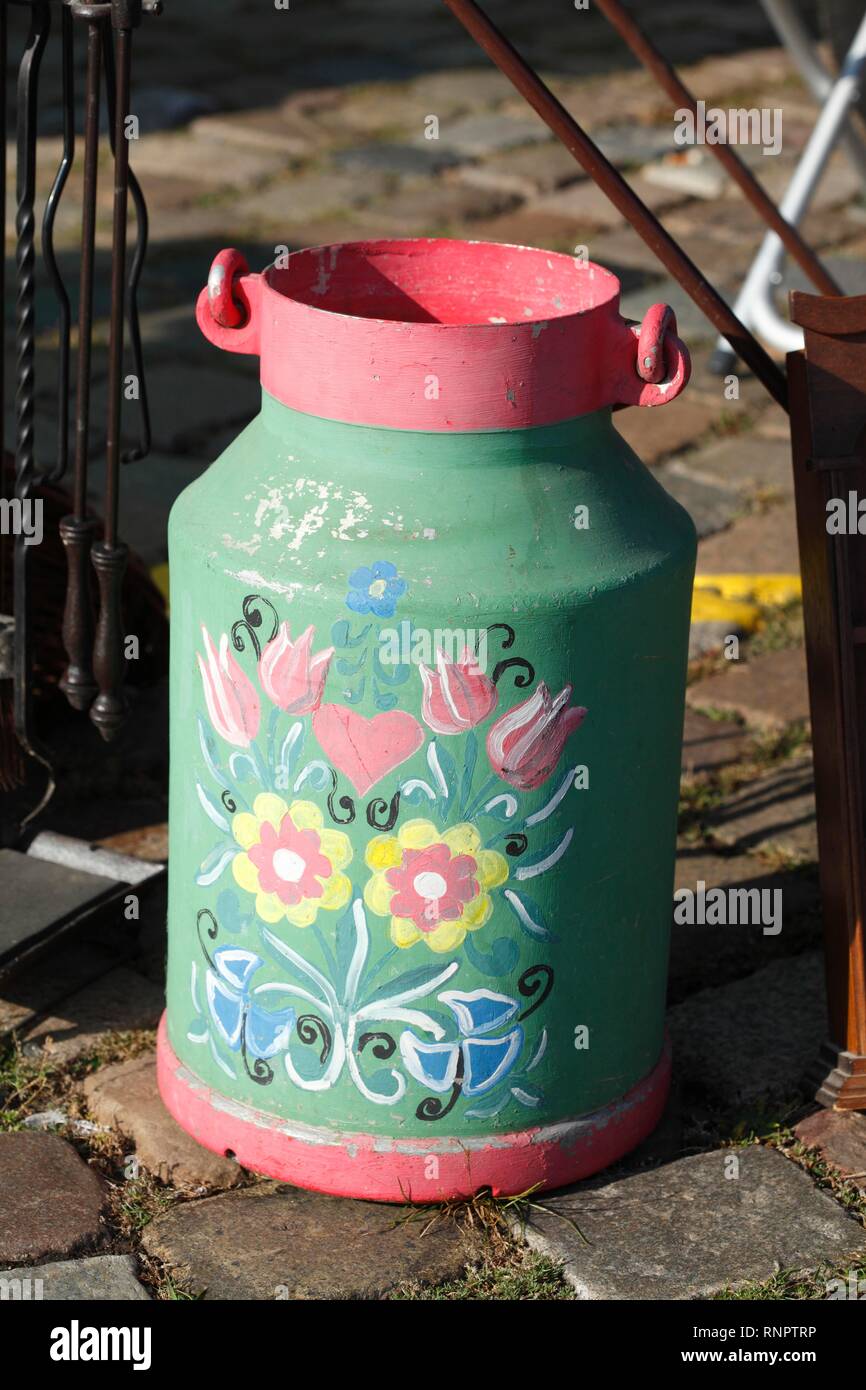 Old colourful milk can at a flea market, Germany Stock Photo