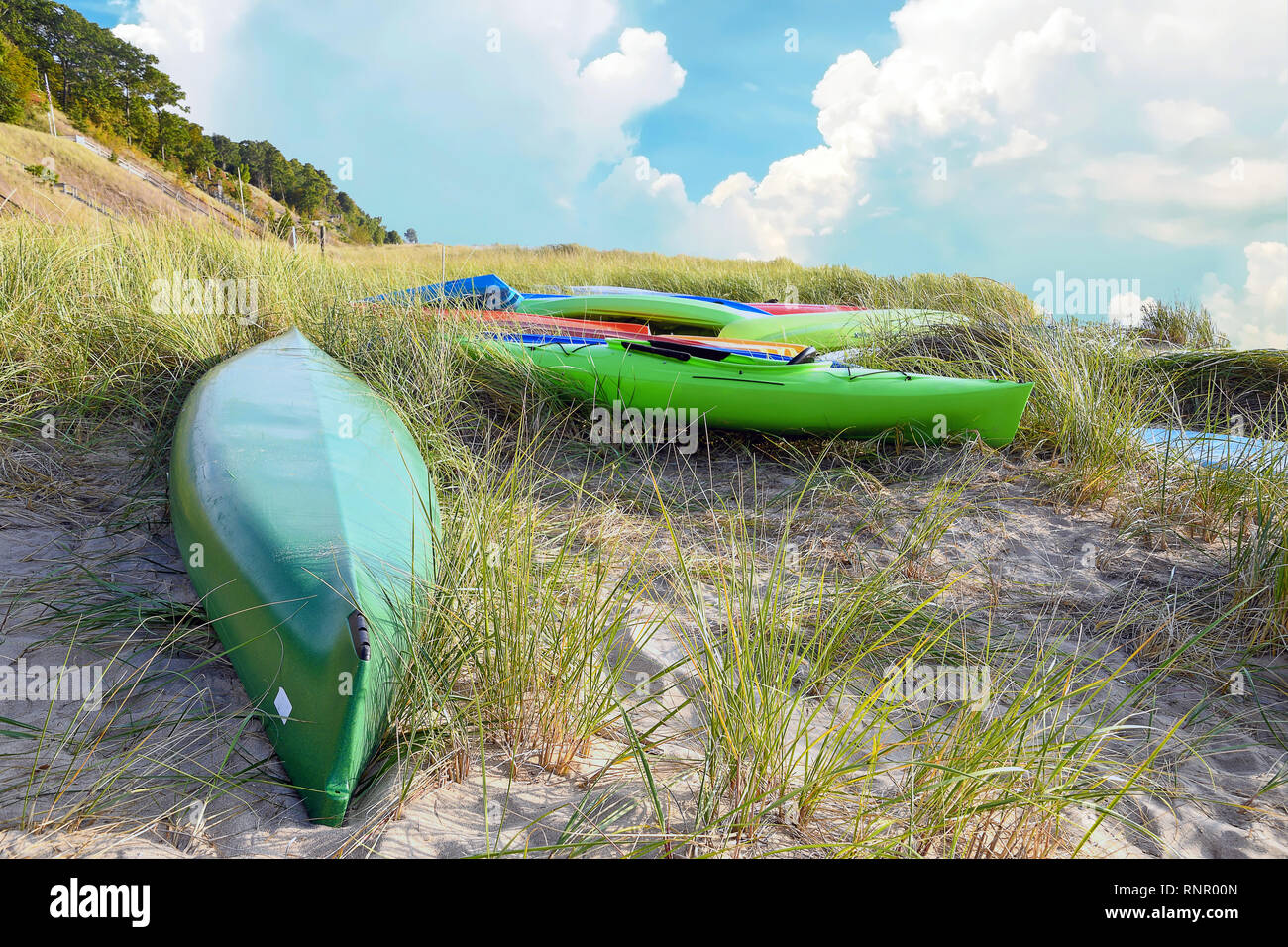 colorful kayaks in dune grass on Lake Michigan beach Stock Photo