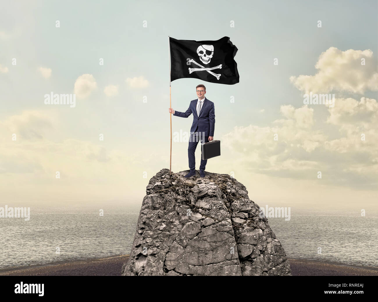 Successful businessman on the top of a mountain holding pirate flag ...