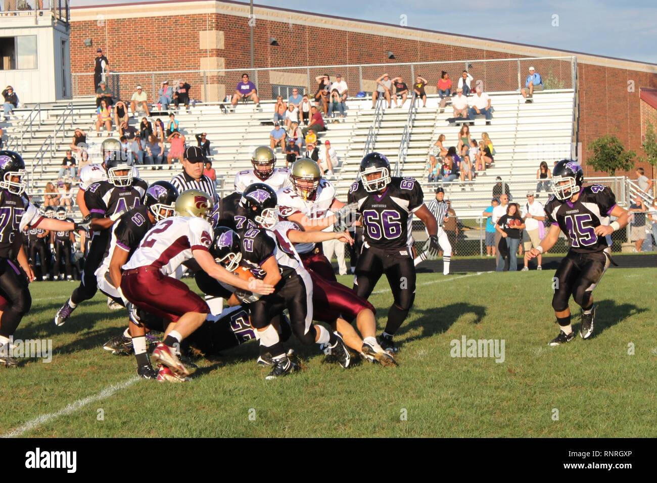 American high school football running back in Virginia with football is  wrapped up by a defender at the line of scrimmage on a sunny afternoon game  Stock Photo - Alamy