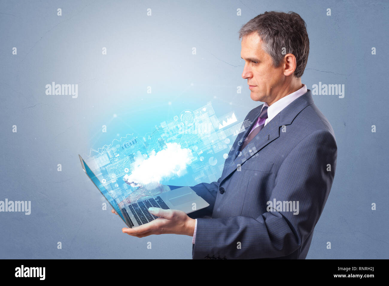 Man holding laptop projecting notifications, symbols and information based on cloud technology system Stock Photo