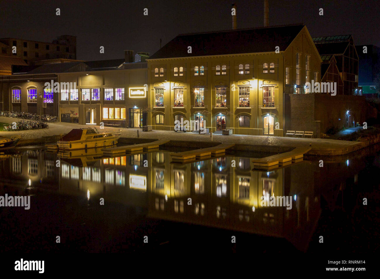Lumiere Cinema at the Bassin city harbor in Maastricht imn the evening with reflections in the