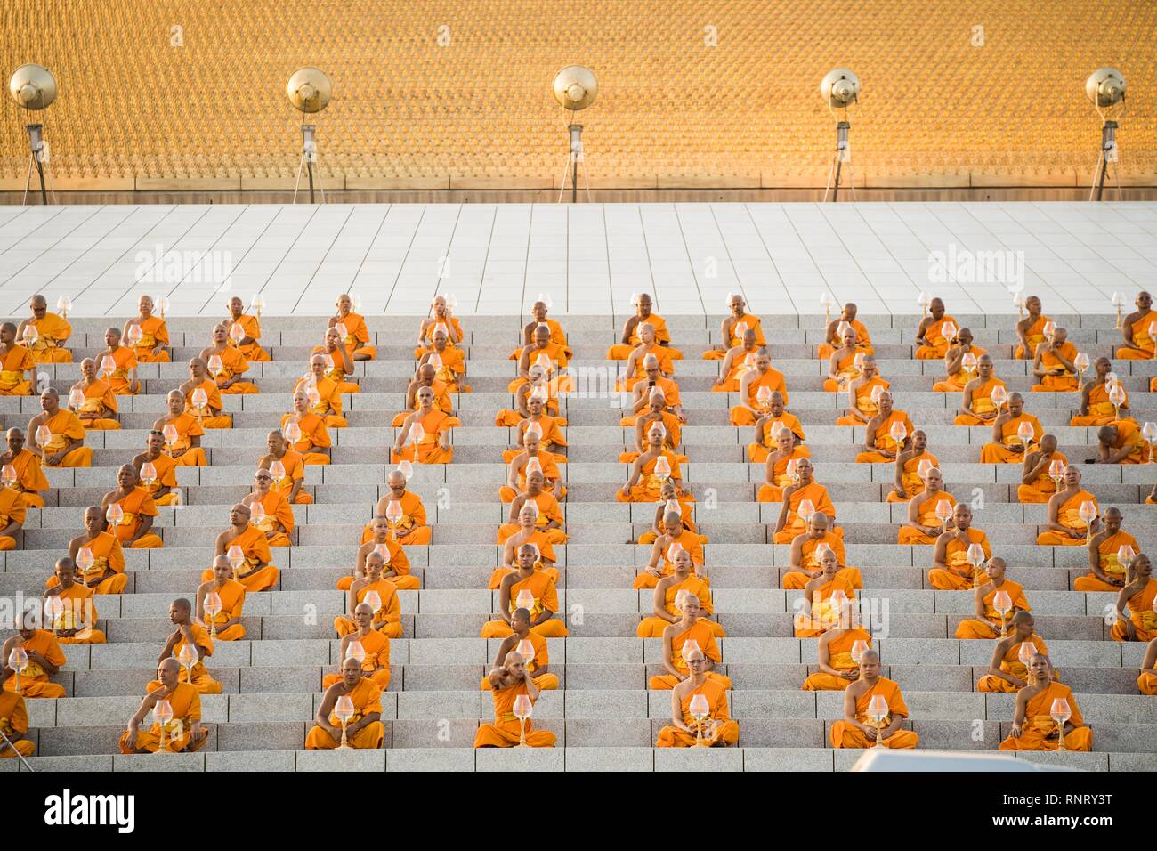 Monks seen praying while holding lanterns during the yearly Makha Bucha ceremony. Buddhist devotees celebrate the annual festival of Makha Bucha, one of the most important day for buddhists around the world. More than a thousand monks and hundred of thousand devotees were gathering at Dhammakaya Temple in Bangkok to attend the lighting ceremony. Stock Photo