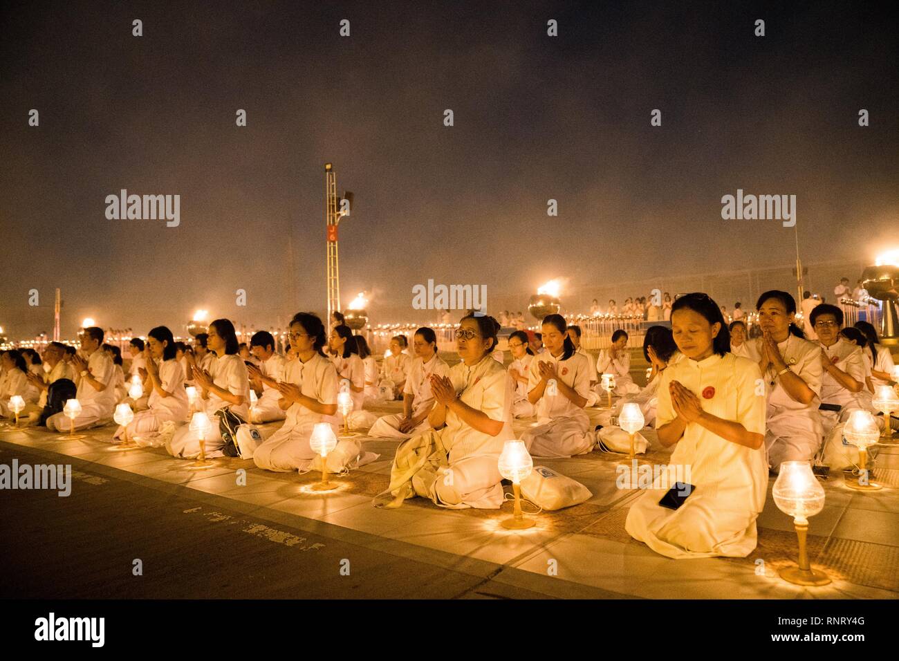 Devotees seen meditating with their lanterns during the yearly Makha Bucha ceremony. Buddhist devotees celebrate the annual festival of Makha Bucha, one of the most important day for buddhists around the world. More than a thousand monks and hundred of thousand devotees were gathering at Dhammakaya Temple in Bangkok to attend the lighting ceremony. Stock Photo