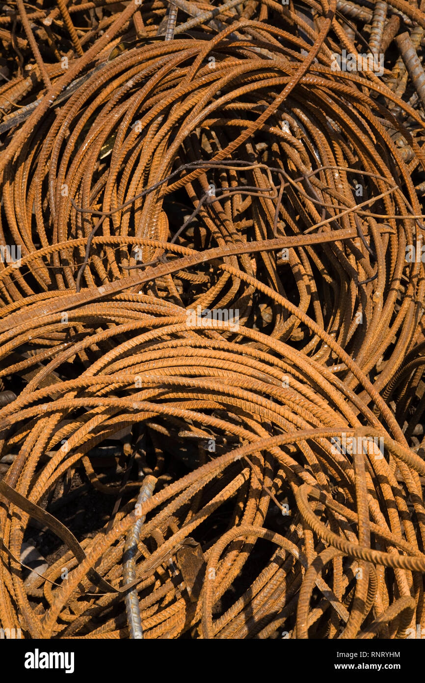 Bundles of rusted ferrous metal rods in a scrap metal recycling yard