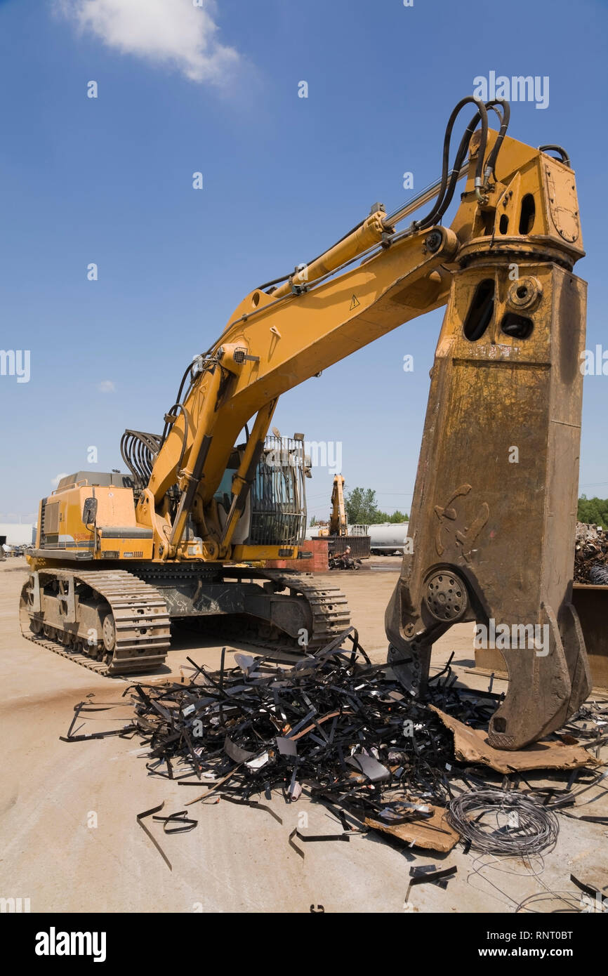 Tracked material handler and pile of discarded metal straps at a scrap