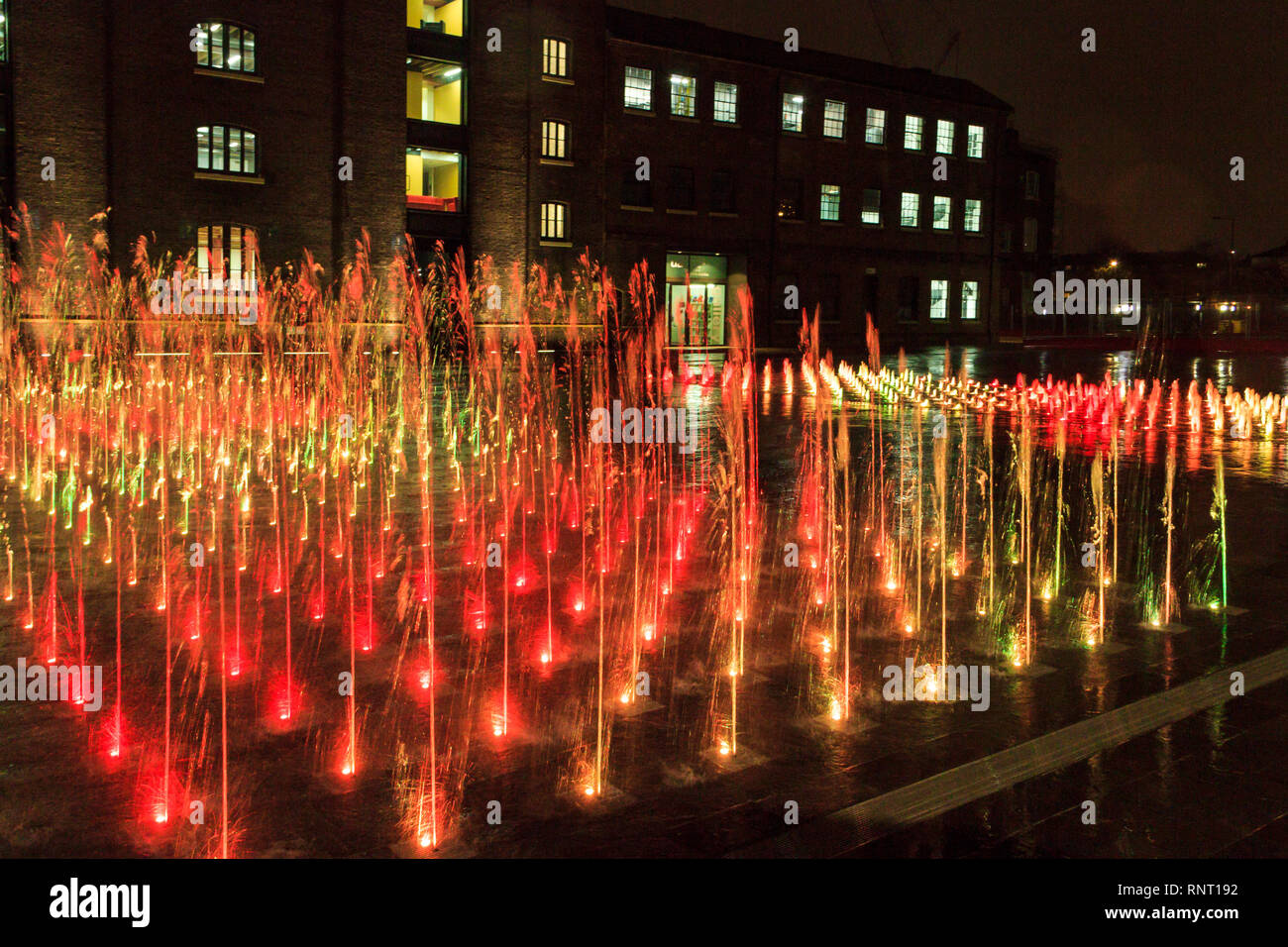 The illuminated fountains in Granary Square at night, King's Cross