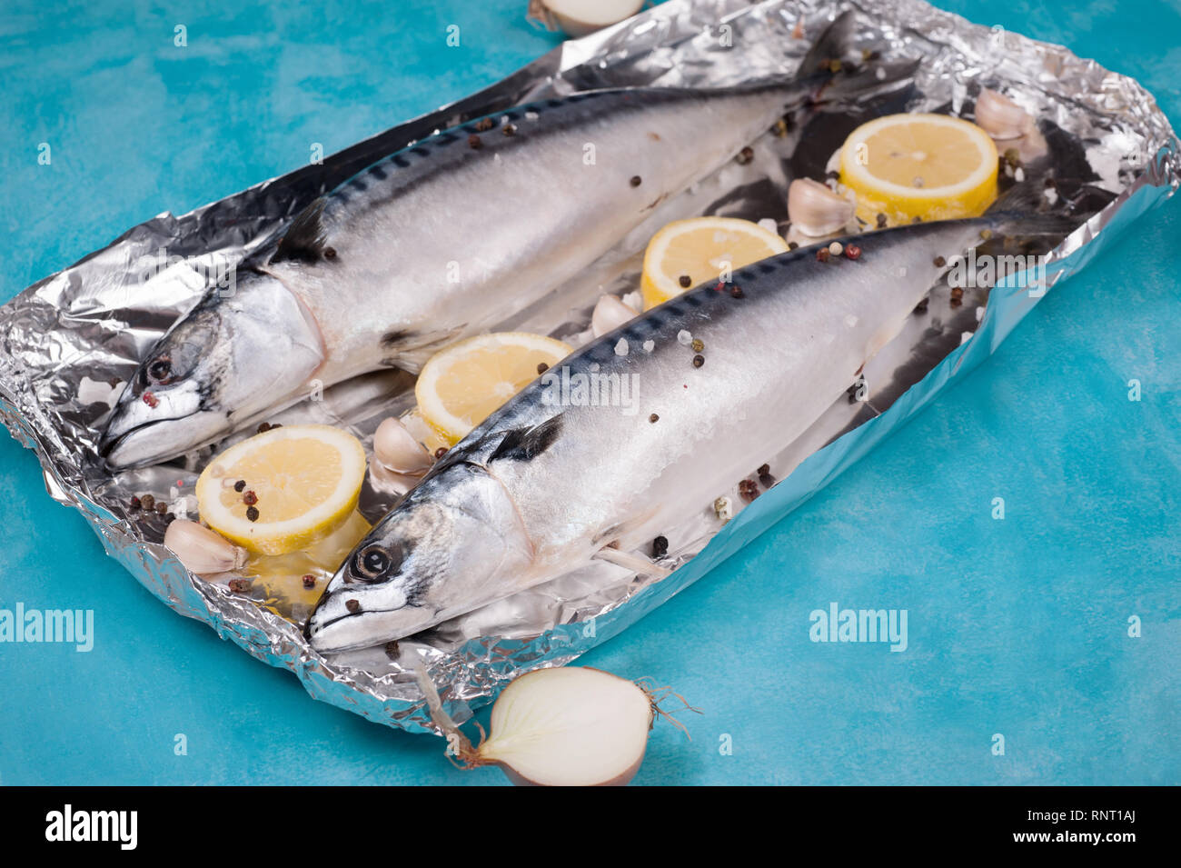 Mackerel fish with ingredients for cooking in the aluminum foil on a