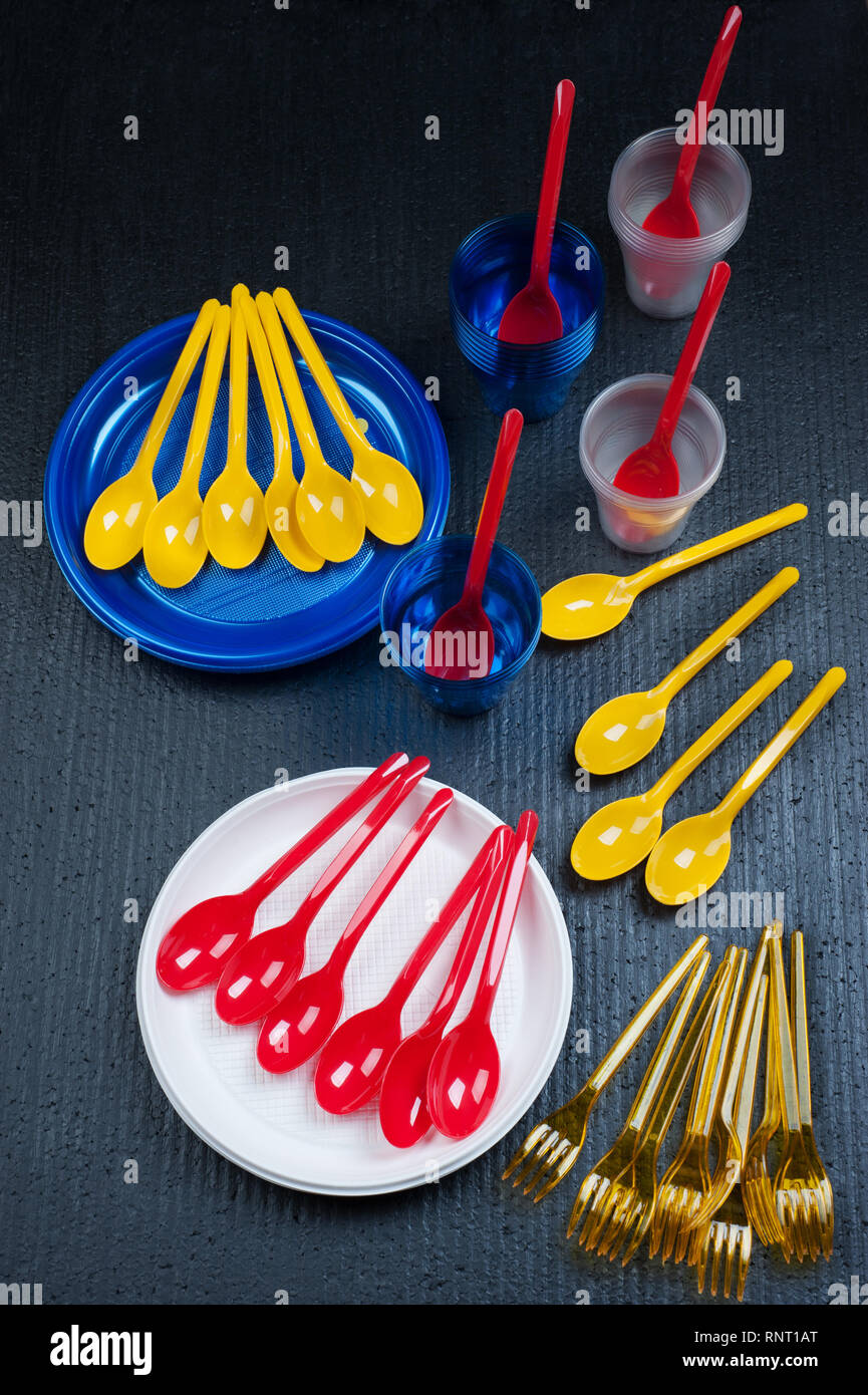 Plastic waste danger .Ecology concept with colorful single use  cutlery on black background. Fake pollution. Stock Photo