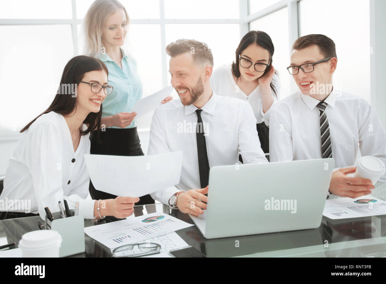 group of self-confident businessmen analyzing data using a laptop Stock Photo