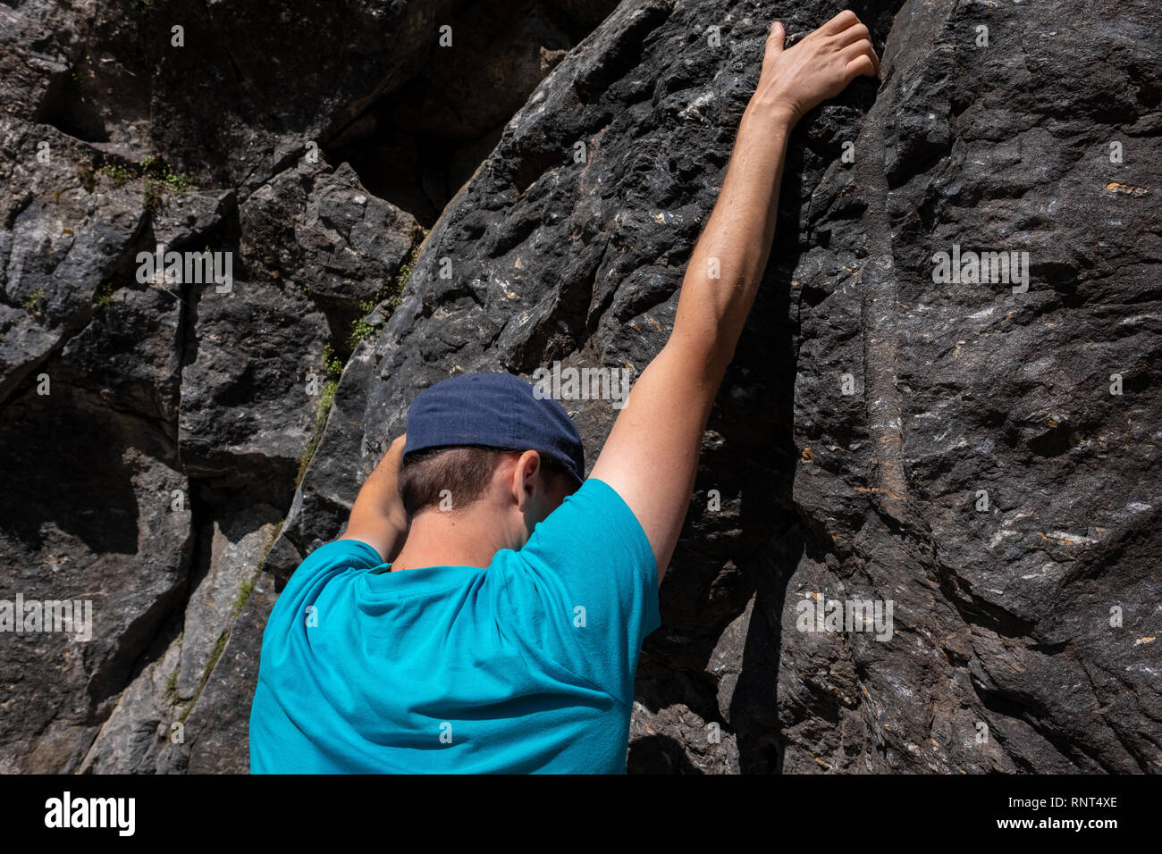 Young caucasian man is climbing on a rock in Switzerland Stock Photo