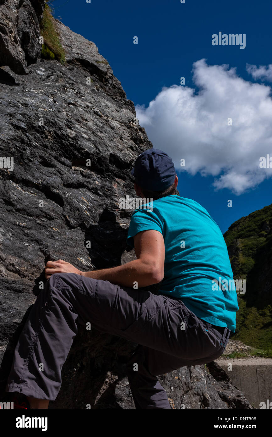 Young caucasian man is climbing on a rock in Switzerland Stock Photo