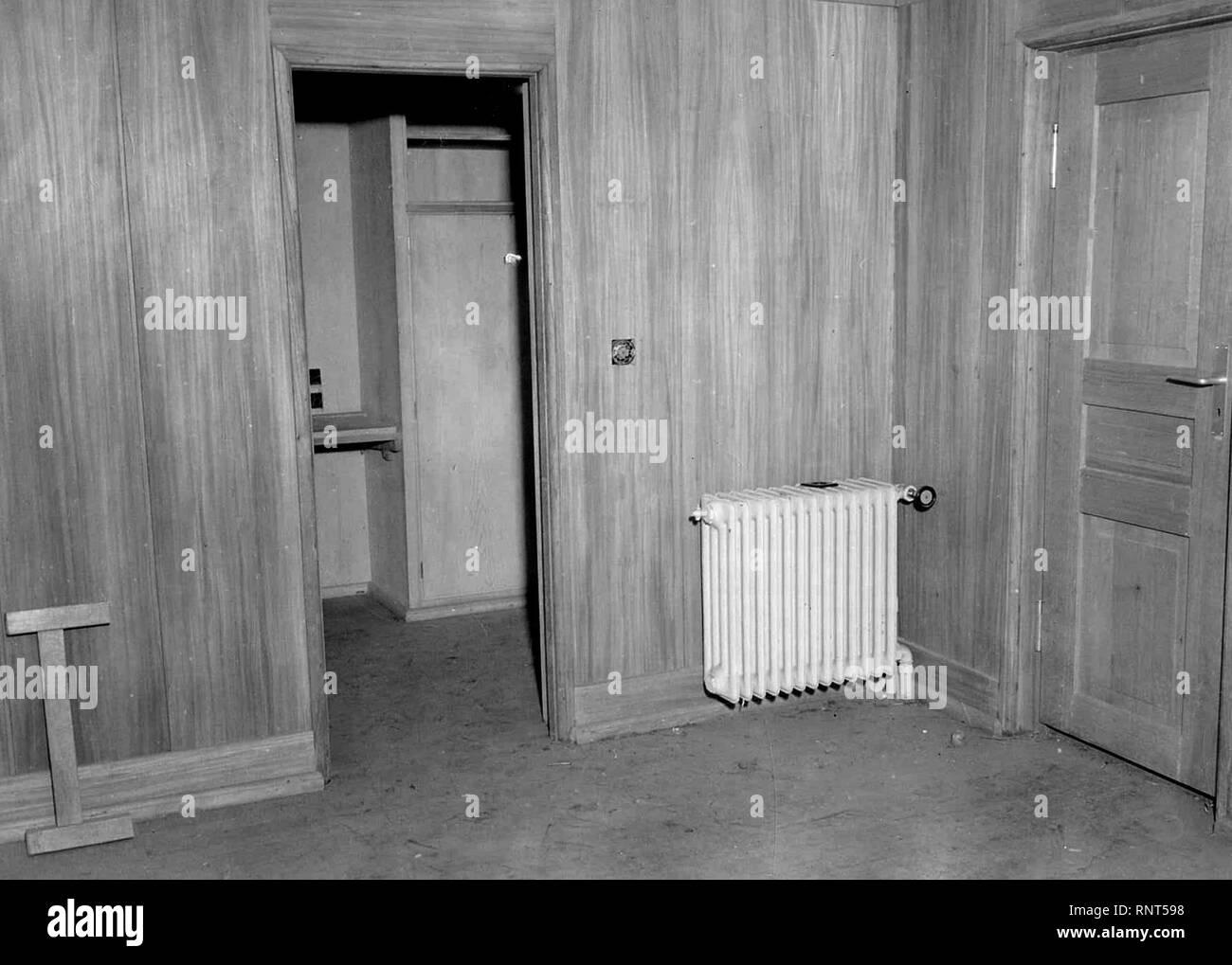 Original Caption: Interior of a bunker cabin looking from the living room into the sleeping compartment. Note the wall paneling, steam heat radiator, light switches; and just over the built in table visible through the doorway are wall plugs for radio and telephones, in an abandoned installation in the hills northwest of Soissons, France. Stock Photo