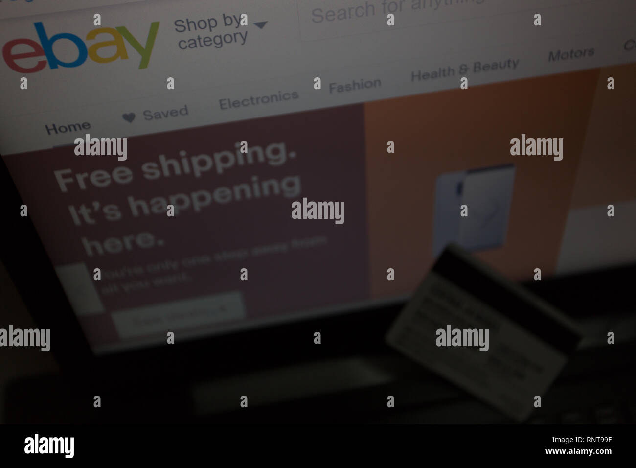 eBay logo on its website is shown on laptop computer screen, credit debit card unfocused, online shoppers, purchases, payments, transactions concept Stock Photo