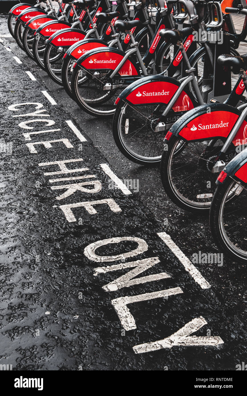 Santander London Bike hire parked in charging racks, otherwise known as Boris bikes. Used for commuting, tourists and for fun, 11,500 bikes available. Stock Photo