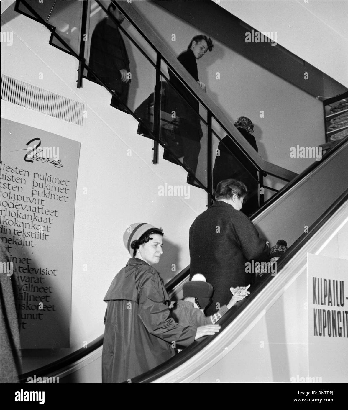 Finland History - Customers trying out an escalator at the opening of a Centrum department store run by Koitto cooperative. ca. 1960s Stock Photo