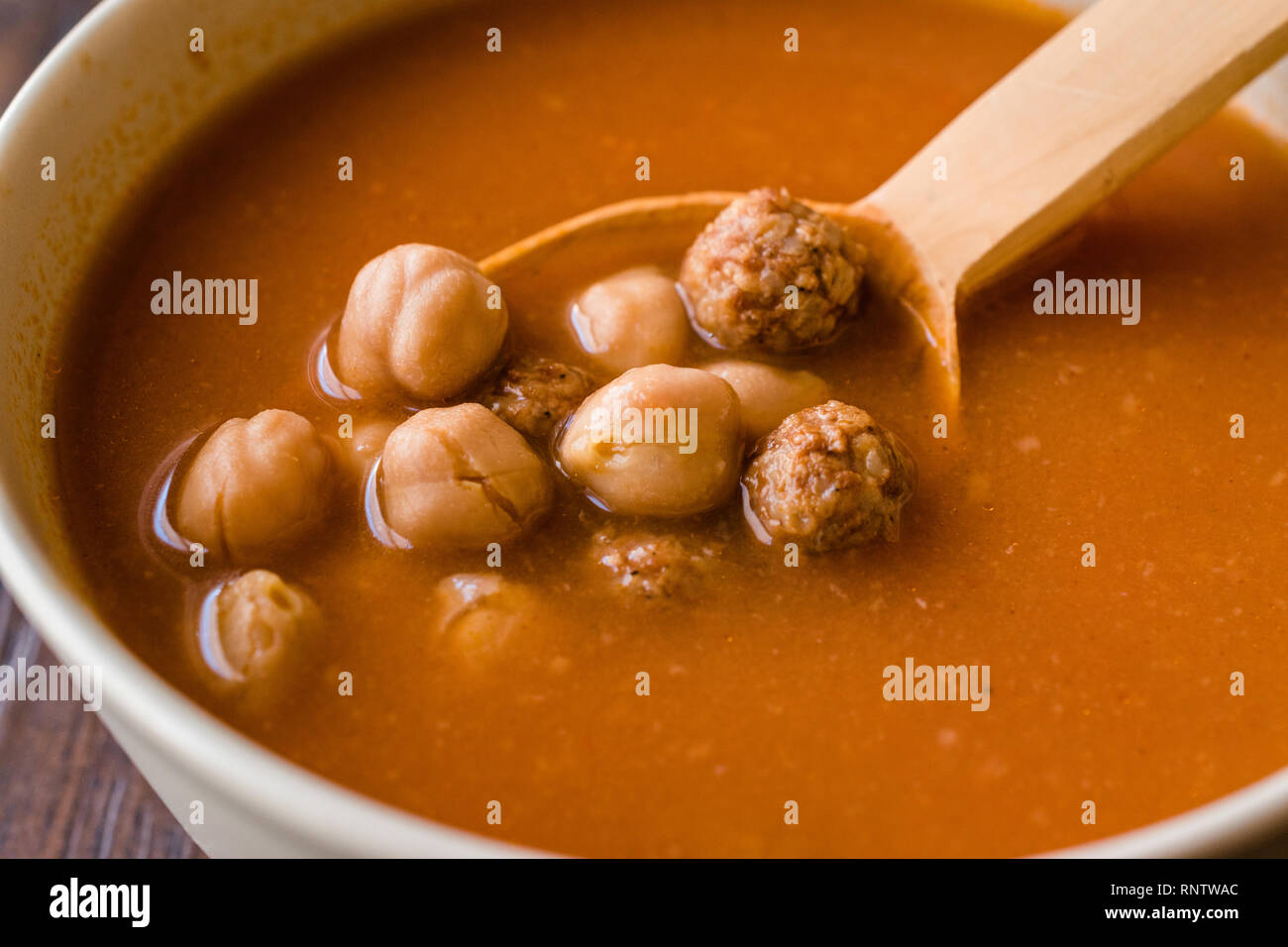 Chickpea Soup Stew with Meatballs and Wooden Spoon / Spanish Potaje de