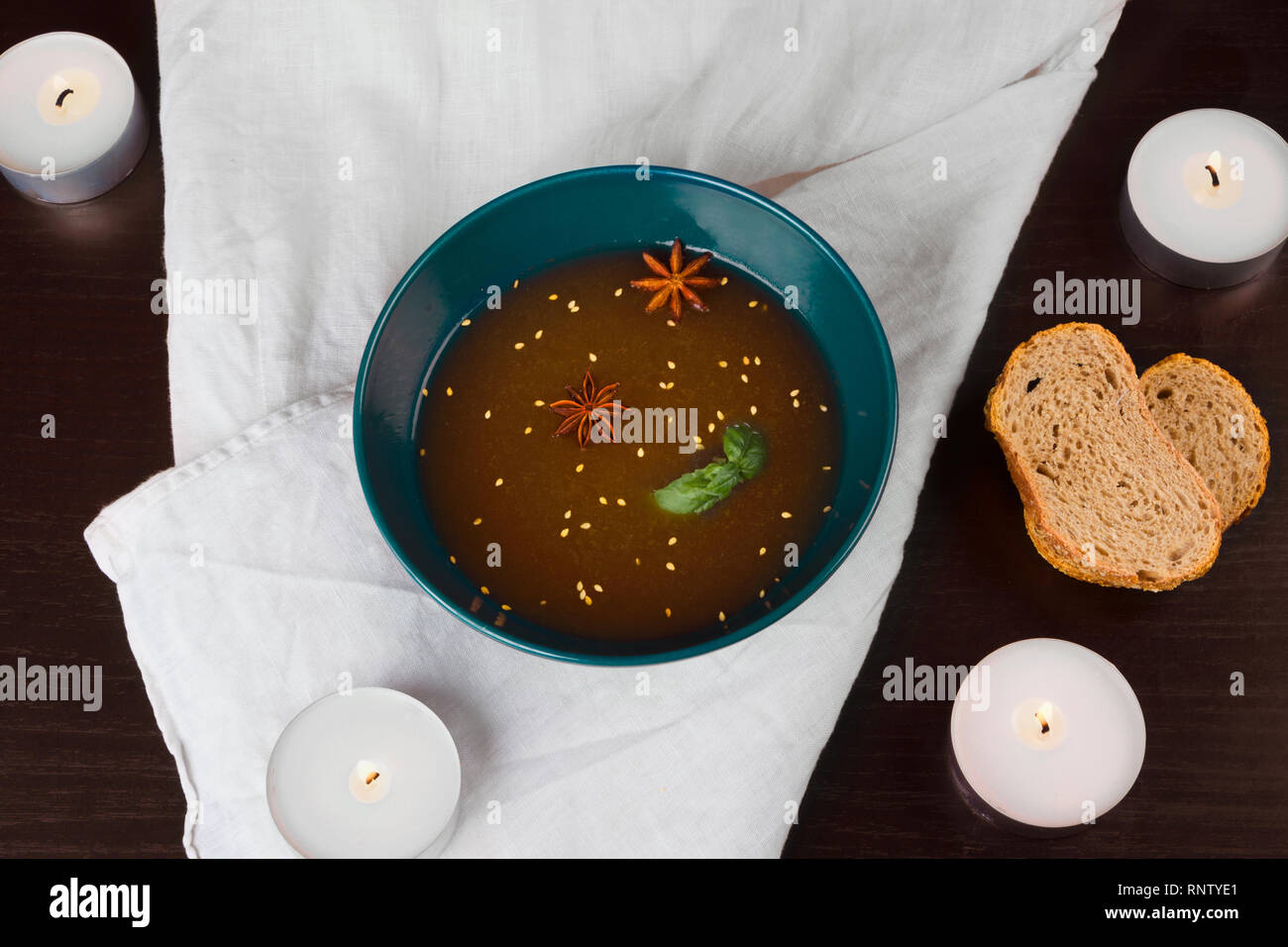 Soup Broth with sesame seeds and aniseed bread and candles Stock Photo Alamy