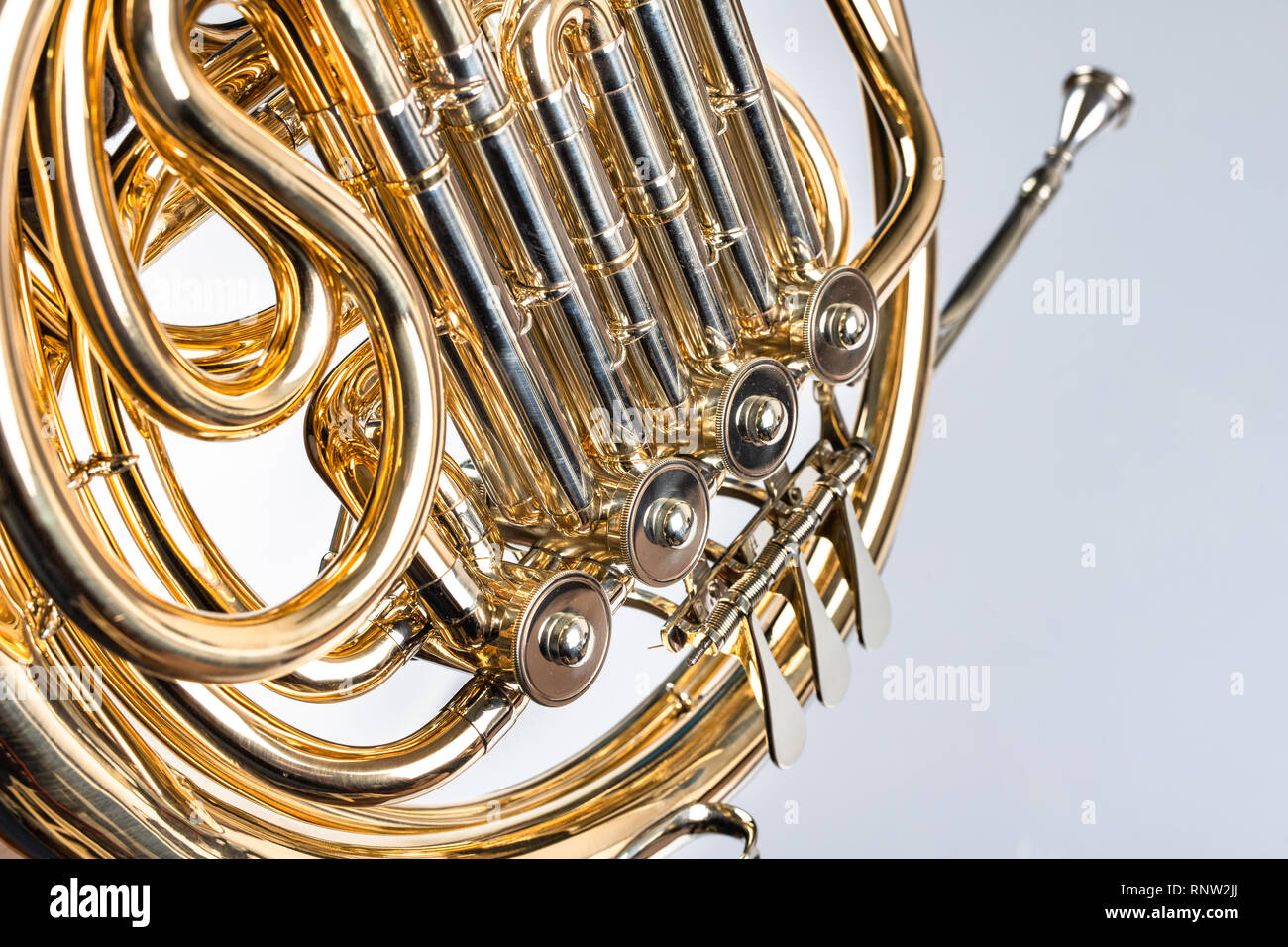 French horn on a white table. Beautiful polished musical instrument. Light  background Stock Photo - Alamy