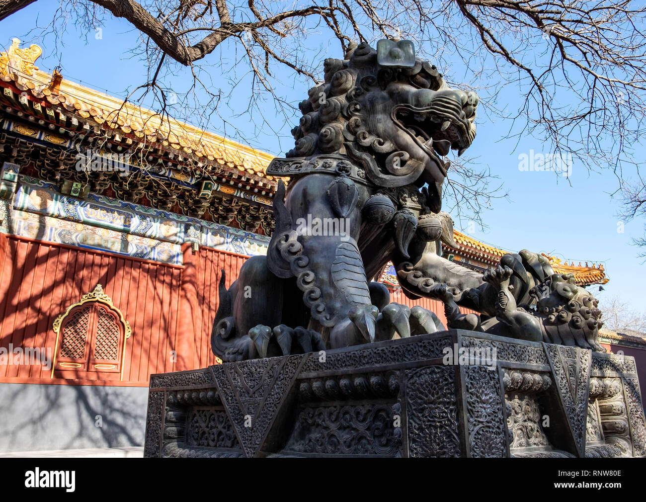 BEIJING/ CHINA, JANUARY 16, 2019: Ancient bronze lion and red chinese paviliones in famous Lama Temple.  This here is one of the destination for trave Stock Photo