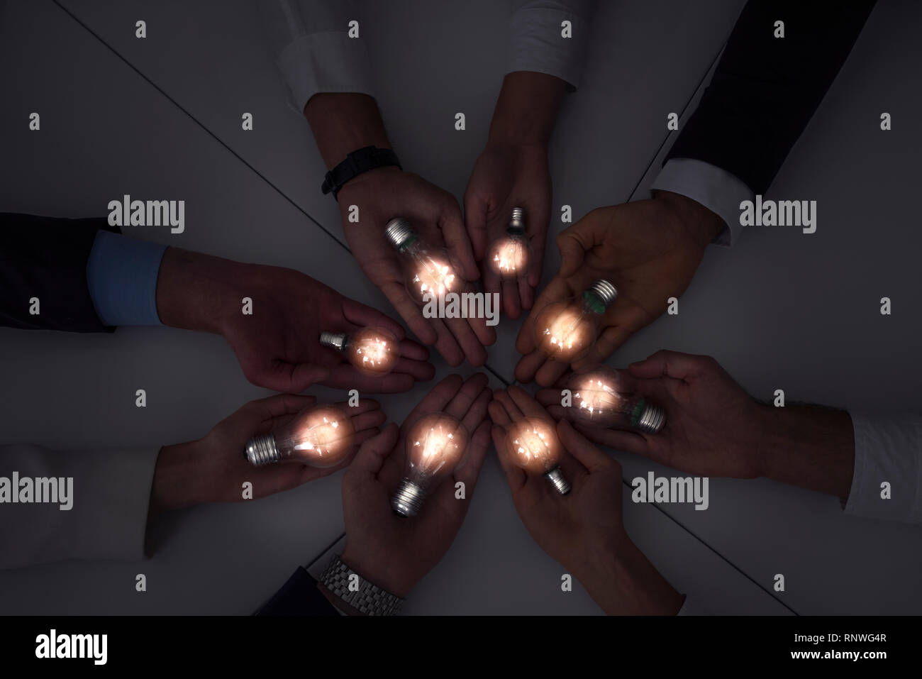 Teamwork and brainstorming concept with businessmen that share an idea with a lamp. Concept of startup Stock Photo