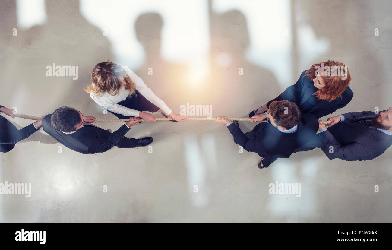 Rival business man and woman compete for the command by pulling the rope. double exposure Stock Photo