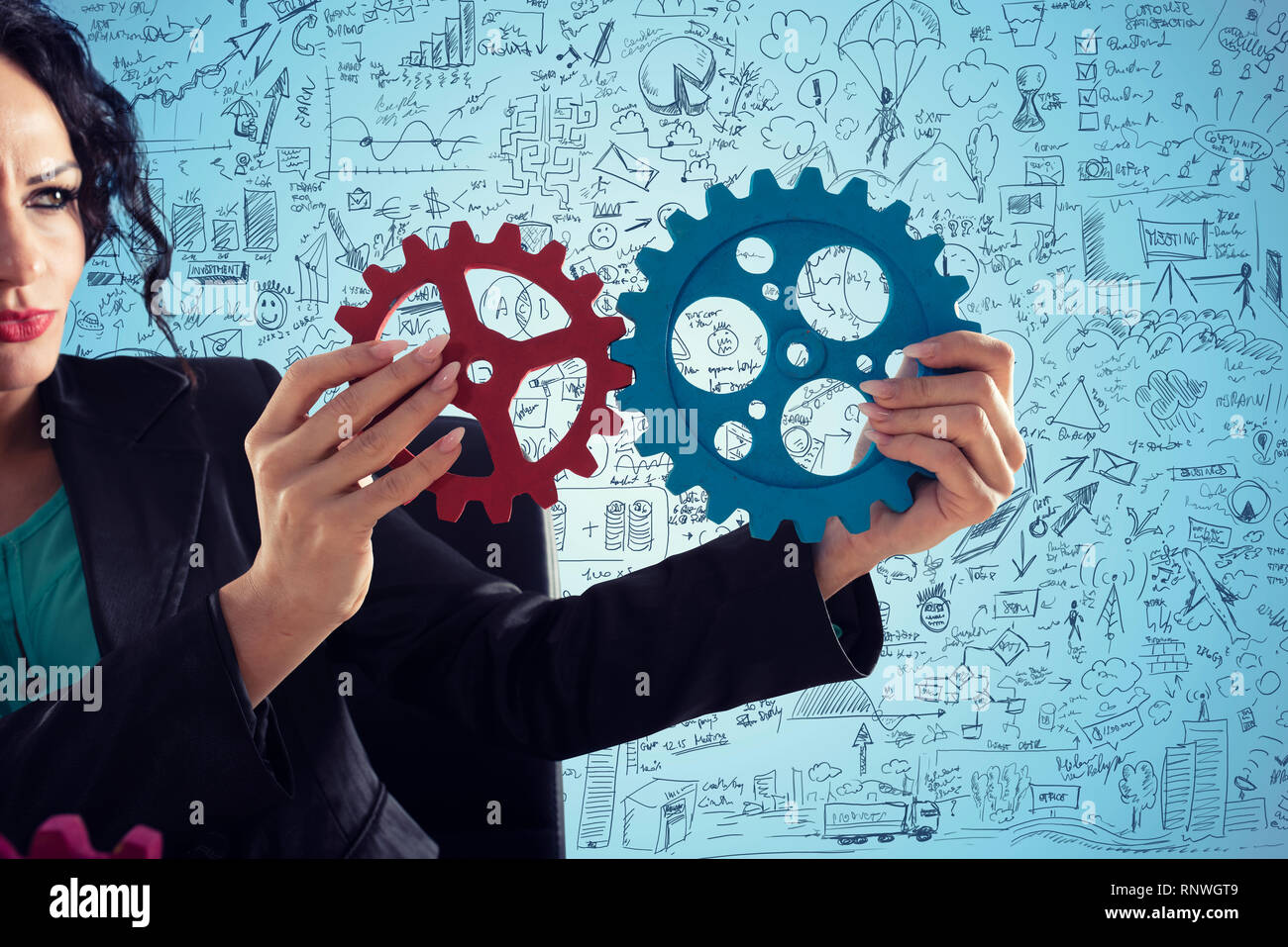 Businesswoman tries to connect gears pieces. Concept of Teamwork, partnership and integration Stock Photo