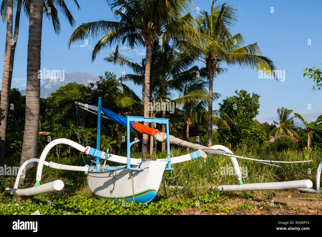 A colorful jukung boat rests on the sand in Bali, Indonesia. Stock Photo