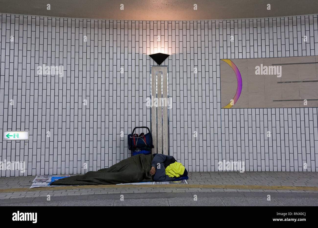 A homeless man sleeps in Hamamatsu Station. Hamamatsu, Shizuoka, Japan. Stock Photo