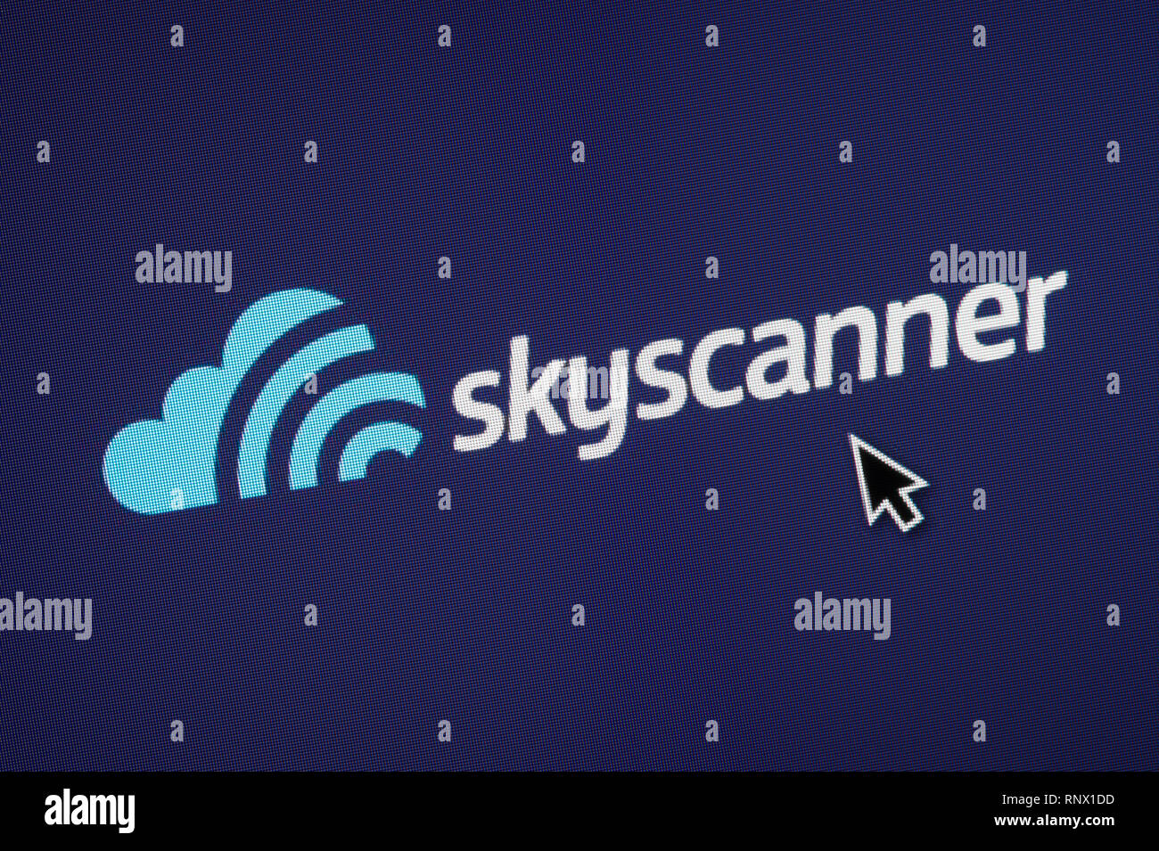 The logo of Skyscanner is seen on a computer screen along with a mouse cursor (Editorial use only) Stock Photo